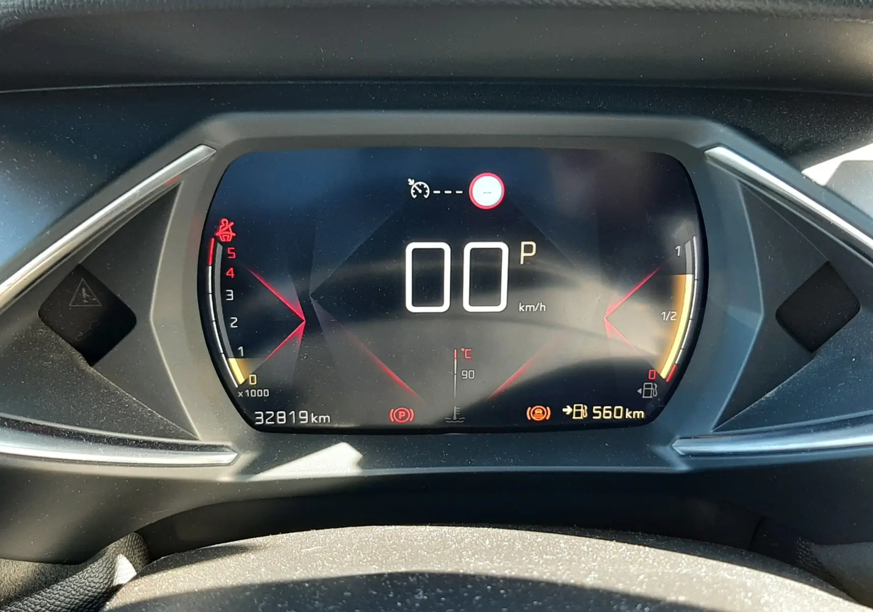 Tableau de bord numérique du DS3 Crossback gris foncé, affichant vitesse à 0 km/h et jauge carburant.