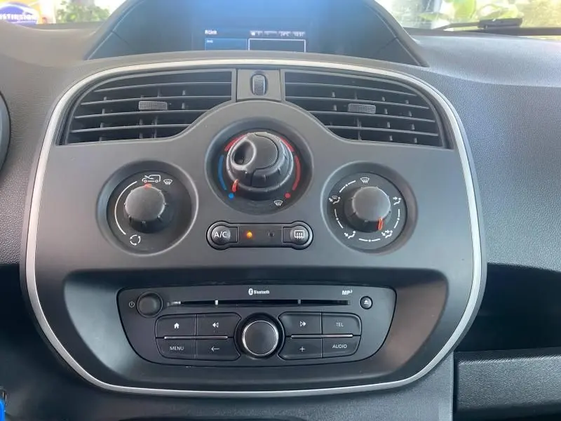 Vue rapprochée du tableau de bord du Renault Kangoo Express 2022, avec commandes climatisation et système audio noir.