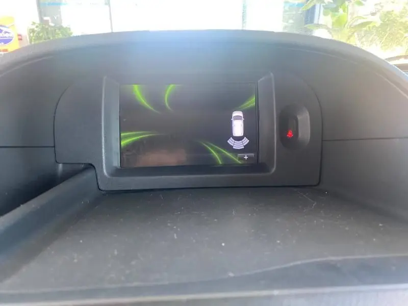 Écran tactile du tableau de bord du Renault Kangoo Express blanc, affichant l'aide au stationnement arrière.