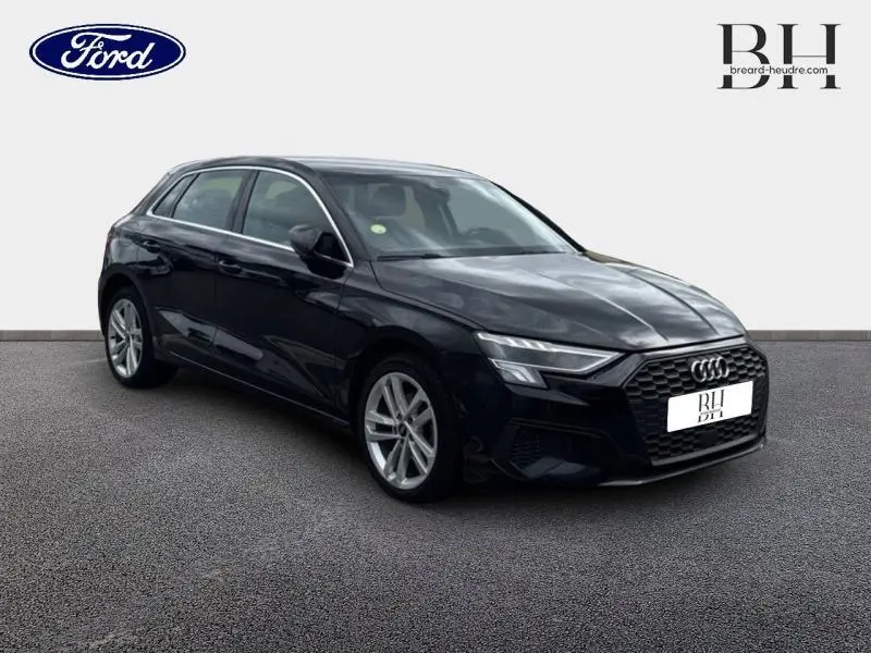 Audi A3 Sportback noir Mythic métallisé vue 3/4 avant droit avec calandre hexagonale et phares LED distinctifs.