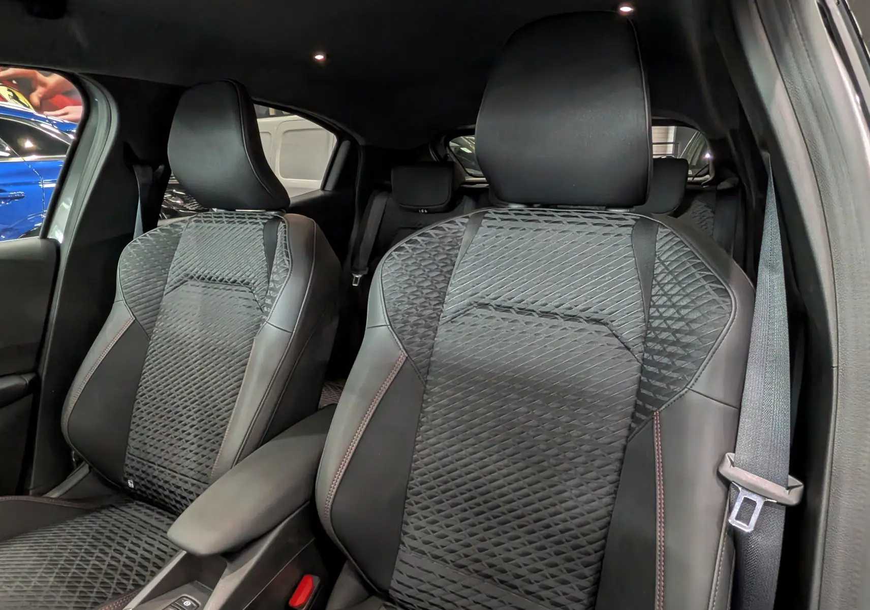 Vue rapprochée des sièges avant en cuir noir avec surpiqûres rouges de la Renault Clio VI TCe 115 CH TECHNO 2026.