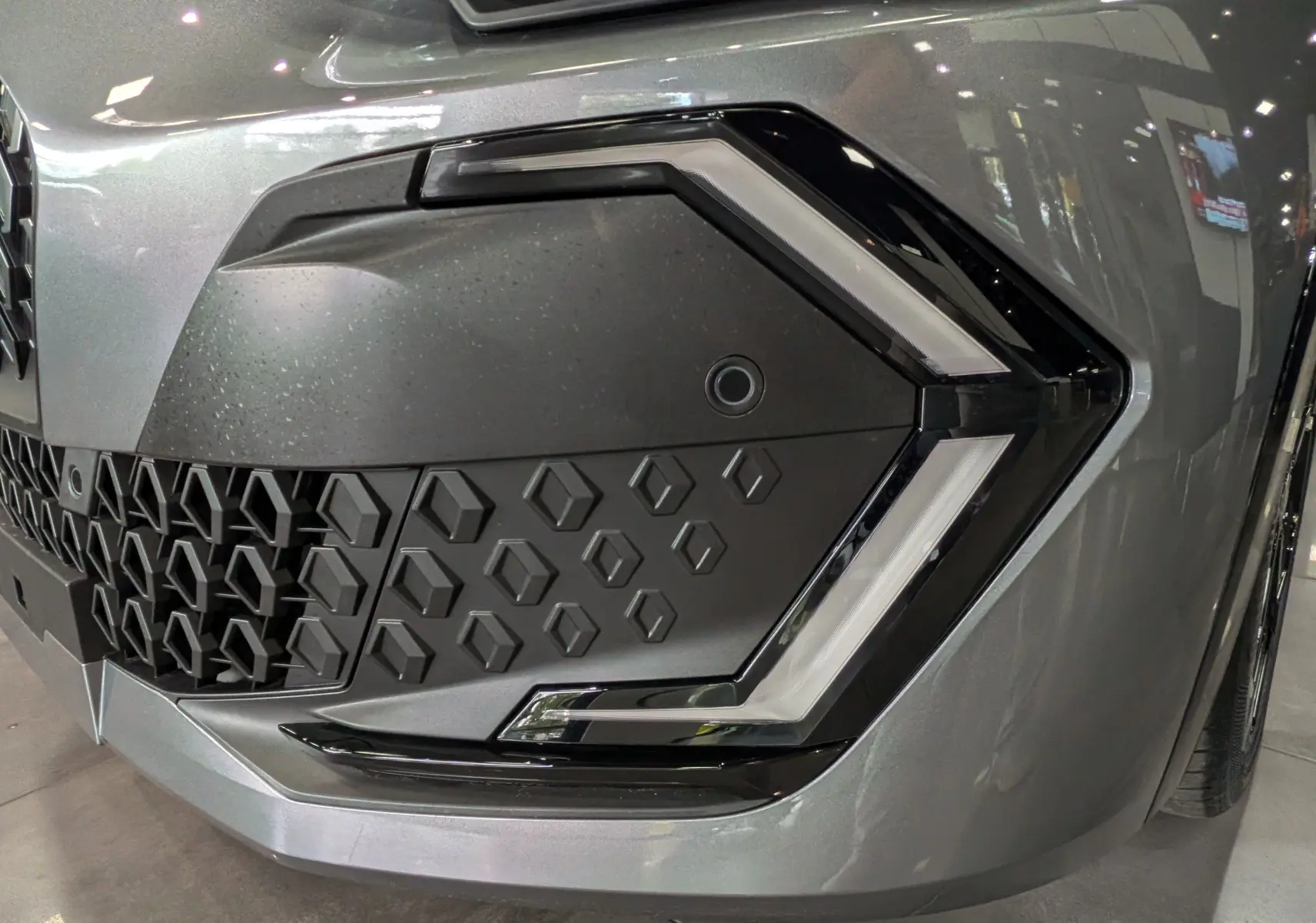 Gros plan sur le phare avant droit gris schiste de la Renault Clio VI TCe 115 TECHNO avec signature lumineuse en forme de C.