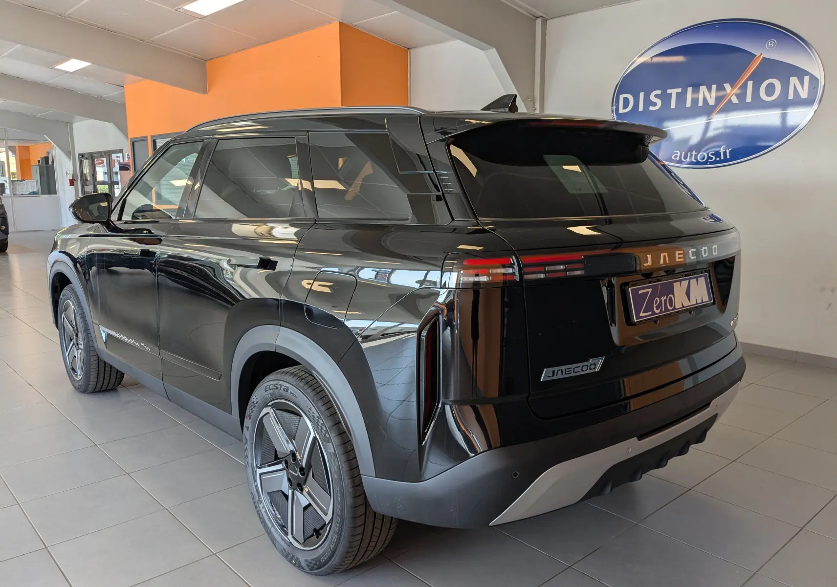 Vue 3/4 arrière droite du JAECOO J7 noir carbone métal, avec feux arrière horizontaux et jantes au design futuriste.