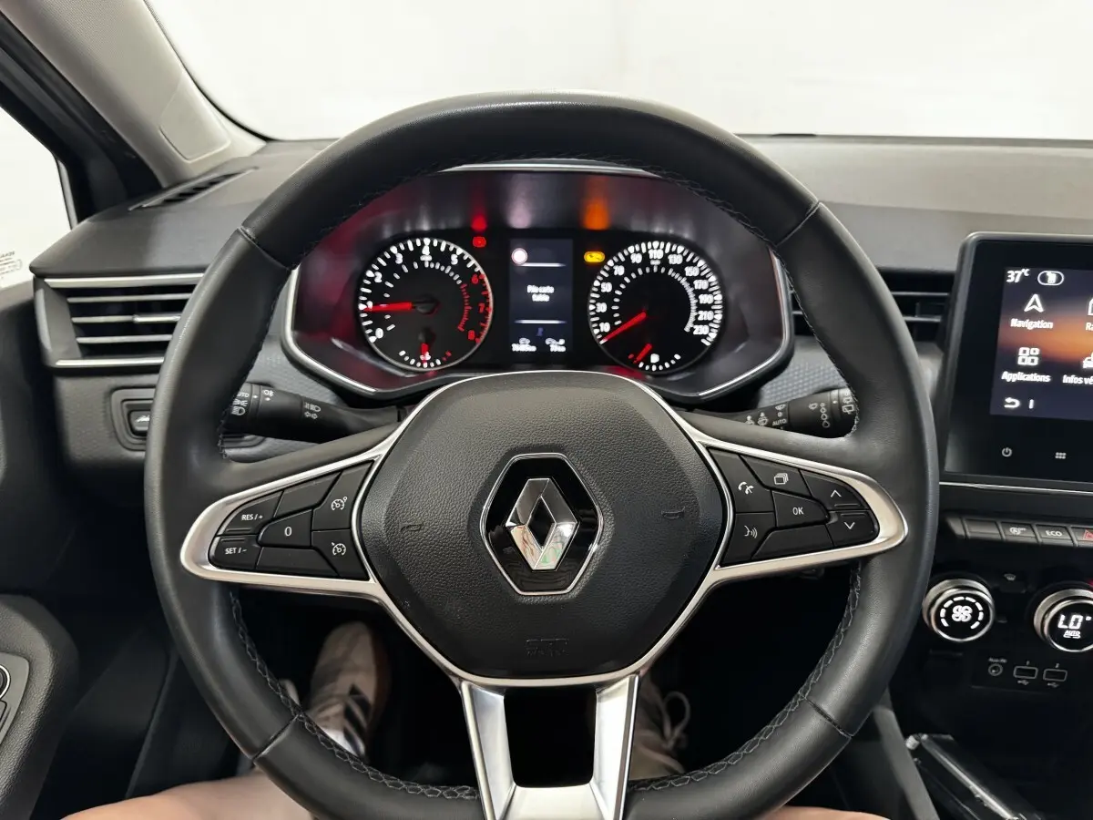 Vue intérieure centrée sur le volant cuir noir de la Renault Clio 2020 avec tableau de bord et écran tactile visibles.