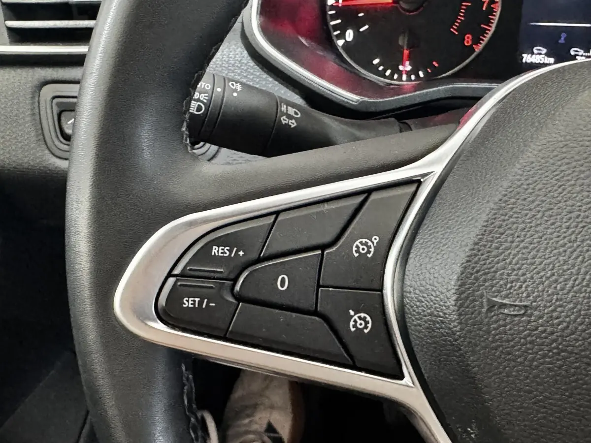 Gros plan sur le volant noir de la Renault Clio Business TCe 90, avec commandes de régulateur de vitesse visibles.