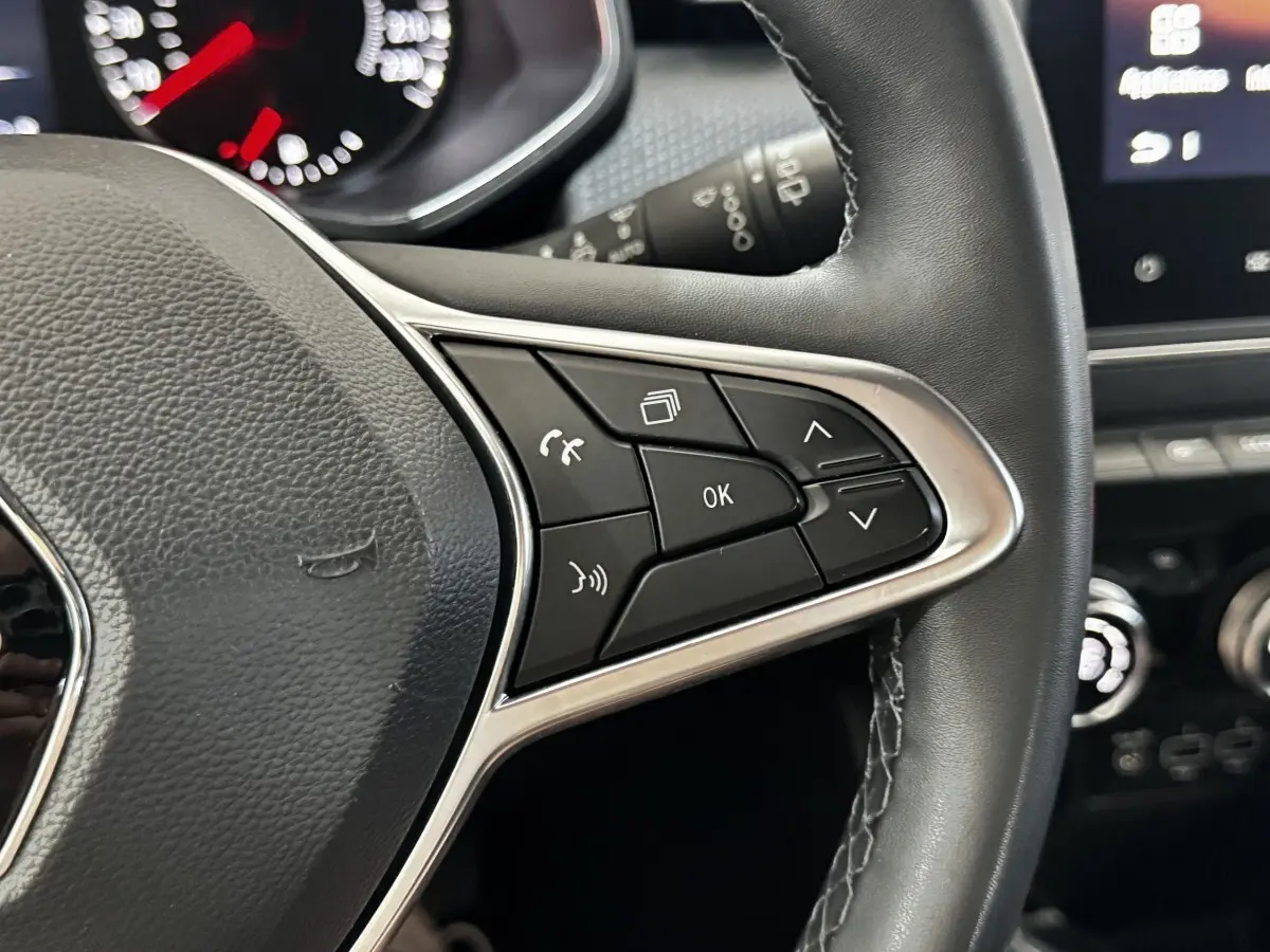 Gros plan sur les commandes multifonctions en cuir noir du volant côté droit de la Renault Clio gris clair 2020.