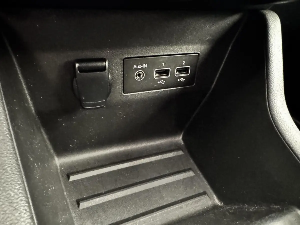Gros plan sur la console centrale noire de la Renault Clio Business TCe 90 avec ports USB et prise Aux-IN visibles.