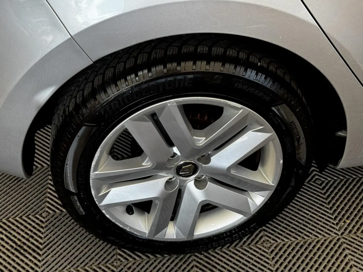 Gros plan sur la roue avant droite gris clair d’une Renault Clio Business TCe 90 2020 avec jante alliage et pneu Bridgestone.