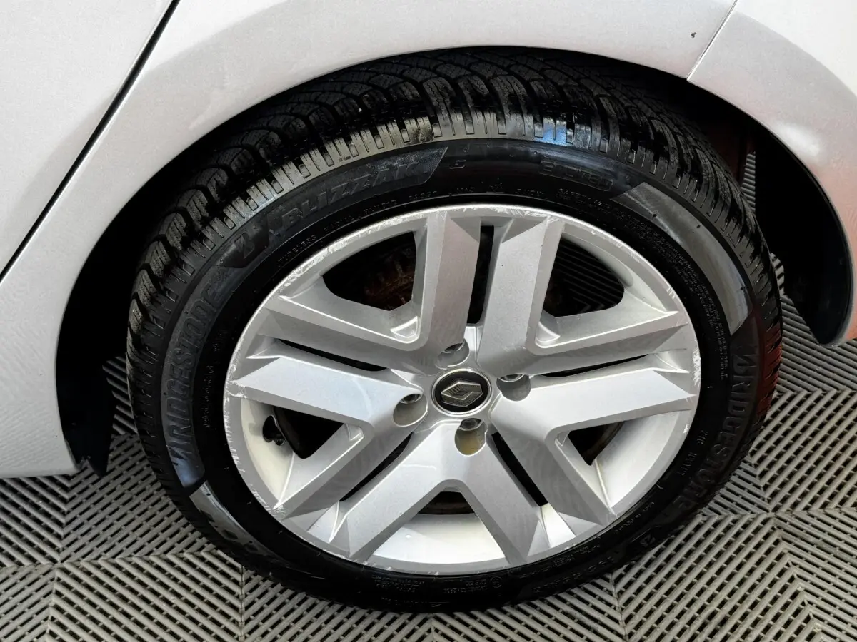 Gros plan sur la roue avant droite gris clair d'une Renault Clio Business TCe 90 avec jante alliage à cinq branches.