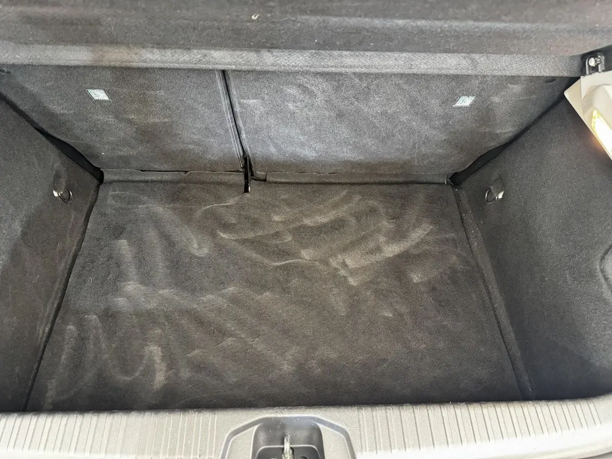 Vue plongeante sur le coffre vide gris foncé de la Renault Clio Business TCe 90 de 2020, avec banquette rabattue.