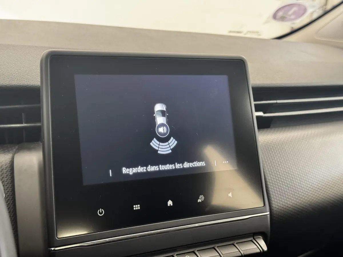 Écran tactile central affichant l'alerte de capteurs de proximité dans l'habitacle d'une Renault Clio gris clair.