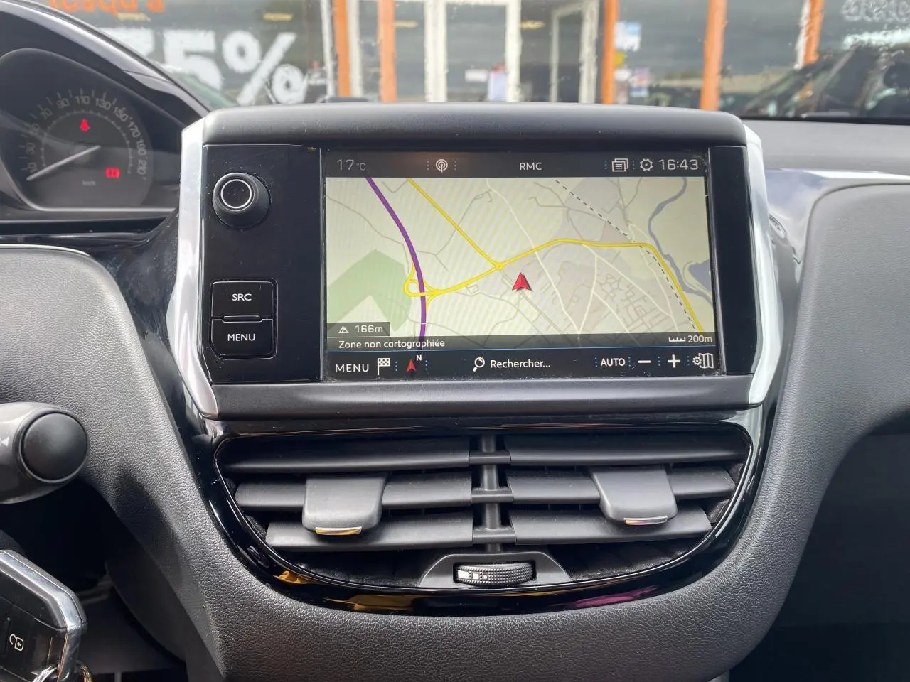 Tableau de bord de Peugeot 208 gris 2018 avec écran tactile affichant la navigation et commandes d'aération.