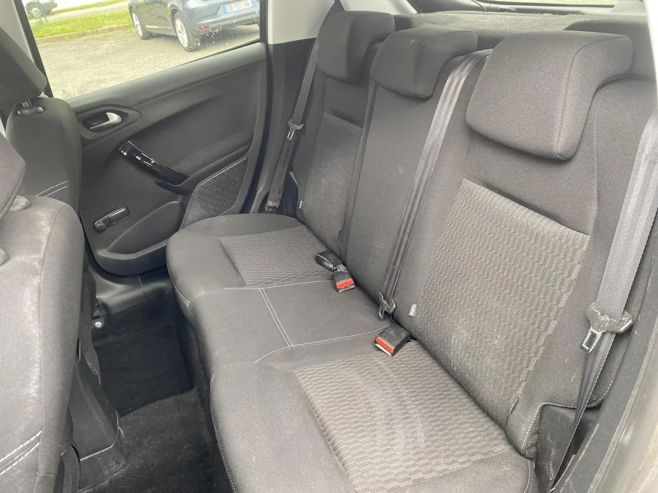 Vue intérieure de la banquette arrière grise du Peugeot 208 2018, avec ceintures et appuie-têtes visibles.