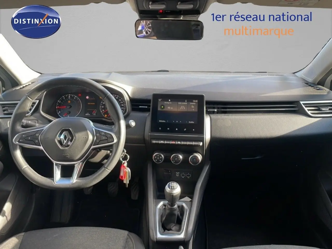 Intérieur de la Renault Clio 2021 vue de face, tableau de bord noir avec écran tactile et levier de vitesse manuel.