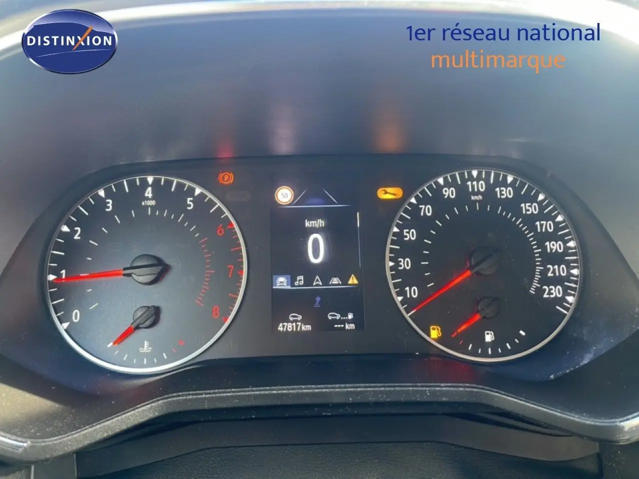 Vue rapprochée du tableau de bord de la Renault Clio blanc glacier 2021, affichant compteur et écran digital.