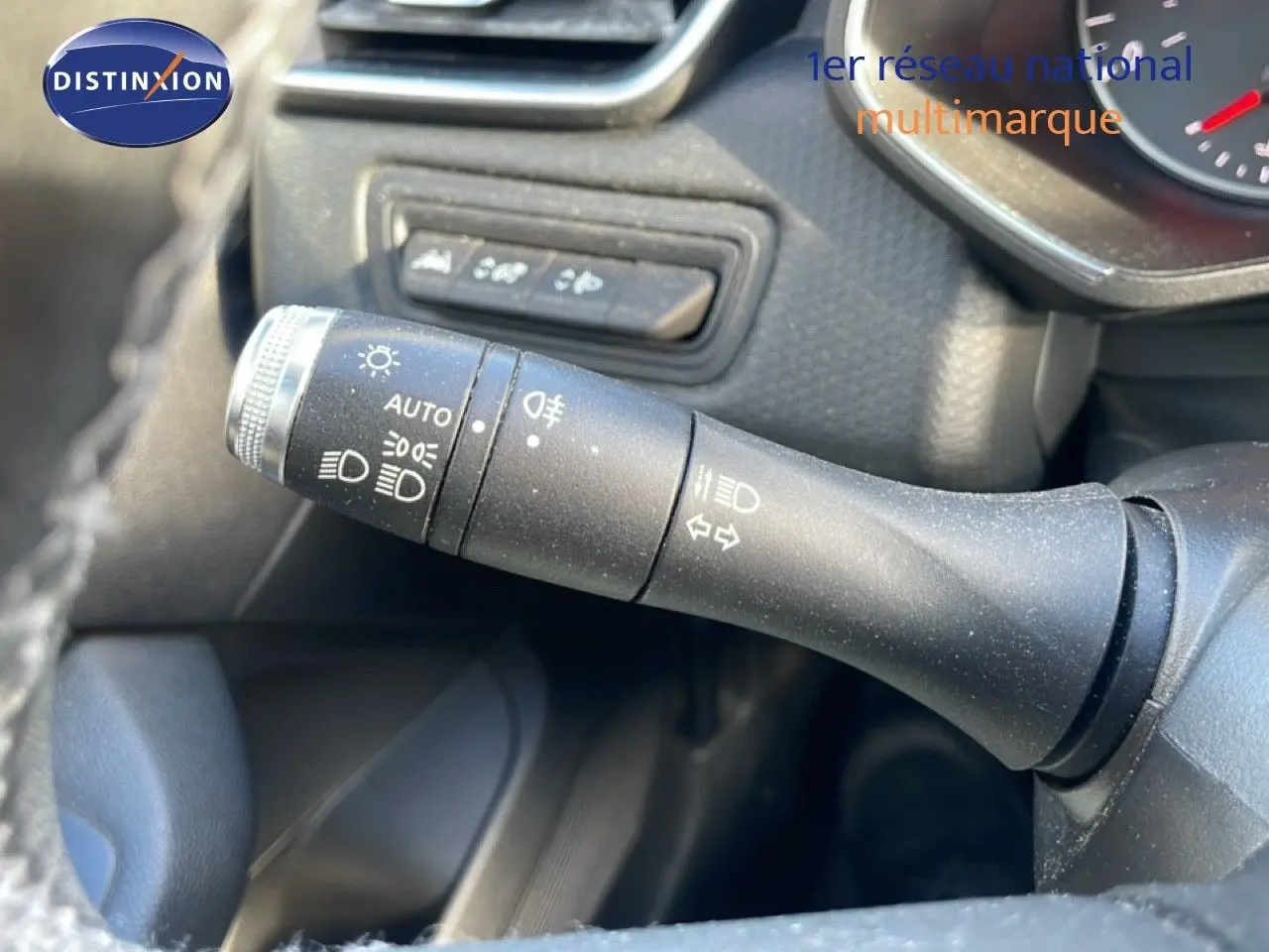 Gros plan sur la commande des phares et clignotants dans l'habitacle d'une Renault Clio blanche Glacier 2021.