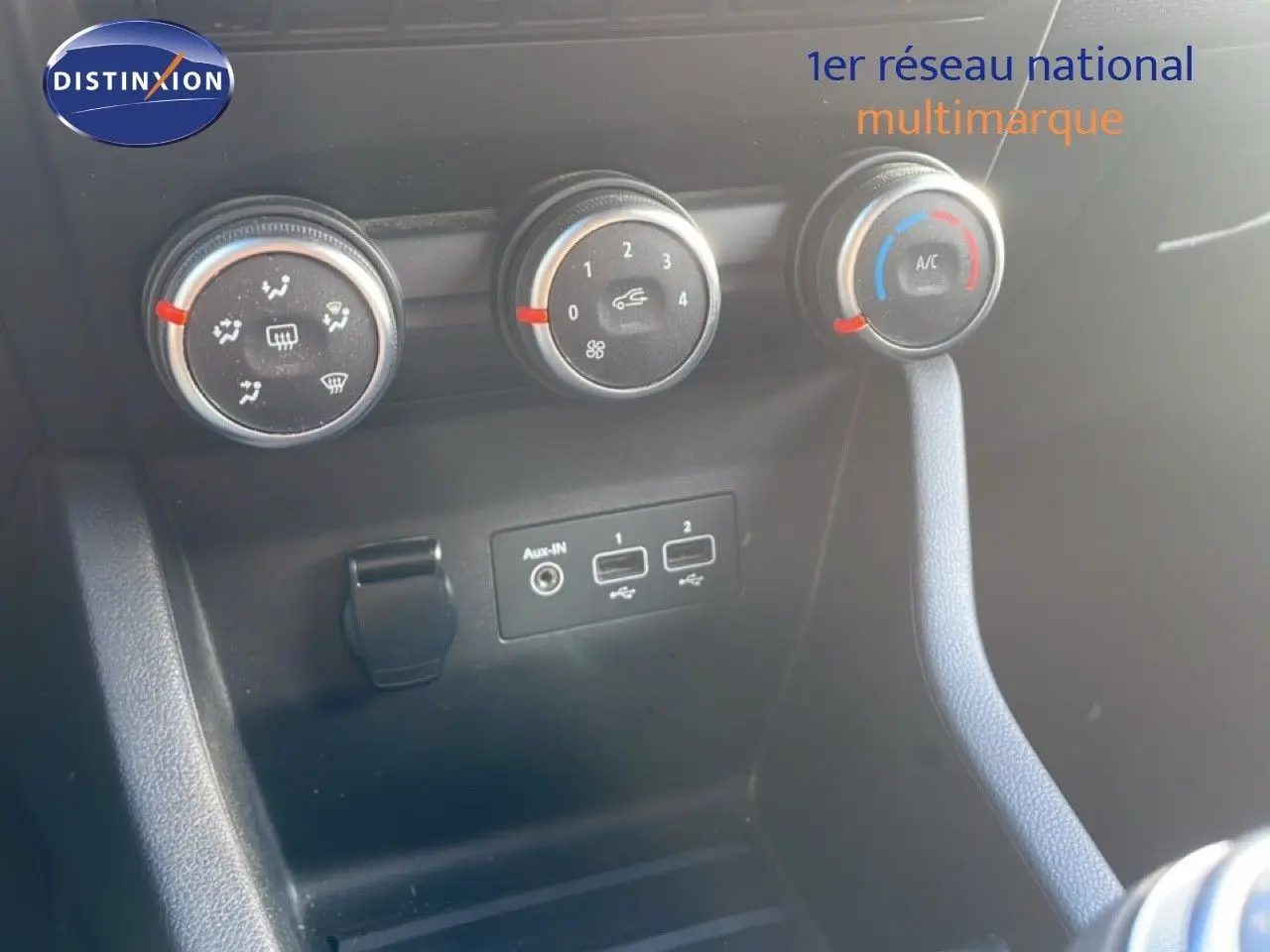 Détail des commandes de climatisation et ports USB dans l'habitacle d'une Renault Clio blanche glacier 2021.