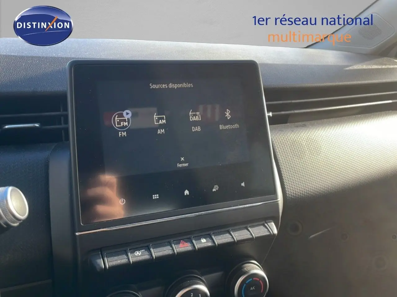 Écran tactile central de la Renault Clio blanc glacier 2021 affichant les sources audio FM, AM, DAB et Bluetooth.