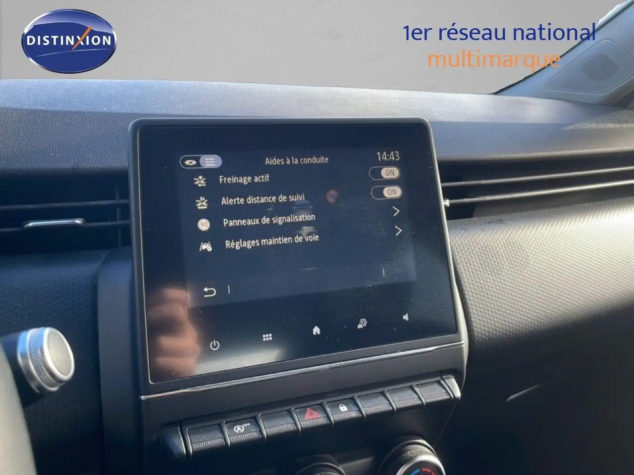 Écran tactile central affichant les aides à la conduite dans l'habitacle d'une Renault Clio blanc glacier, vue de face.