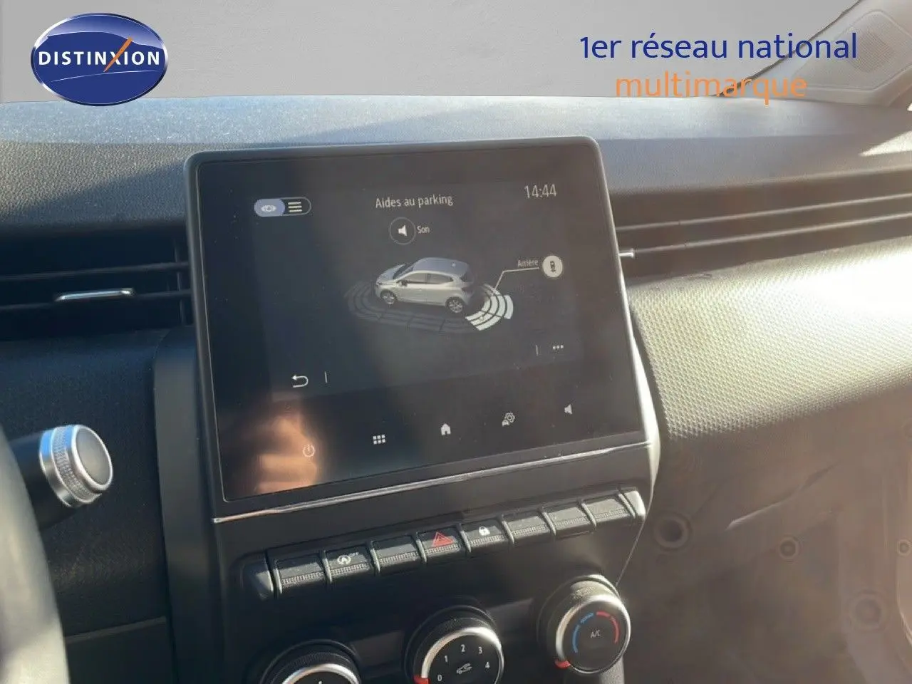 Écran tactile central affichant l'aide au parking dans l'habitacle d'une Renault Clio blanche glacier de 2021.