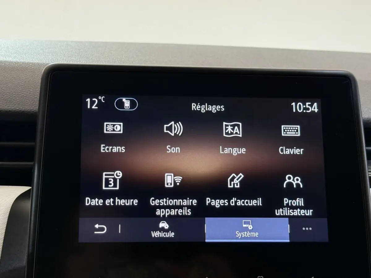 Écran tactile central de la Renault Clio blanc, affichant le menu Réglages avec icônes claires.