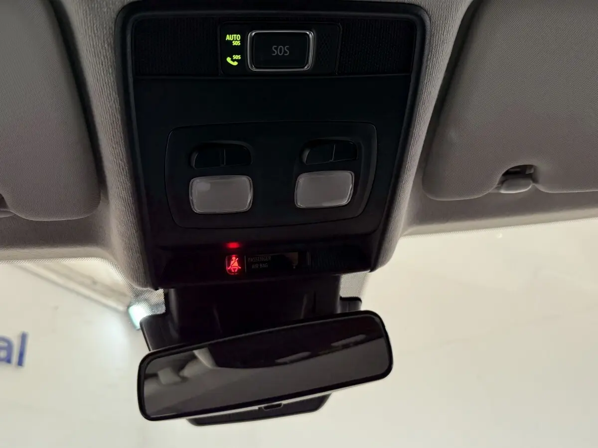 Vue intérieure du plafonnier et rétroviseur d’une Renault Clio blanche 2023 avec bouton SOS et éclairage intégré.