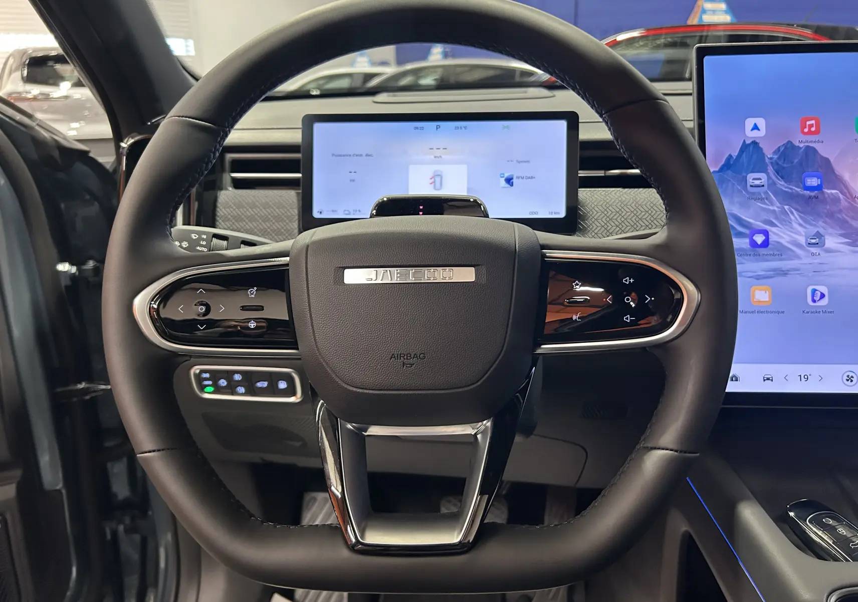 Vue frontale du volant noir du JAECOO J7 2026 avec tableau de bord numérique et écran tactile latéral.