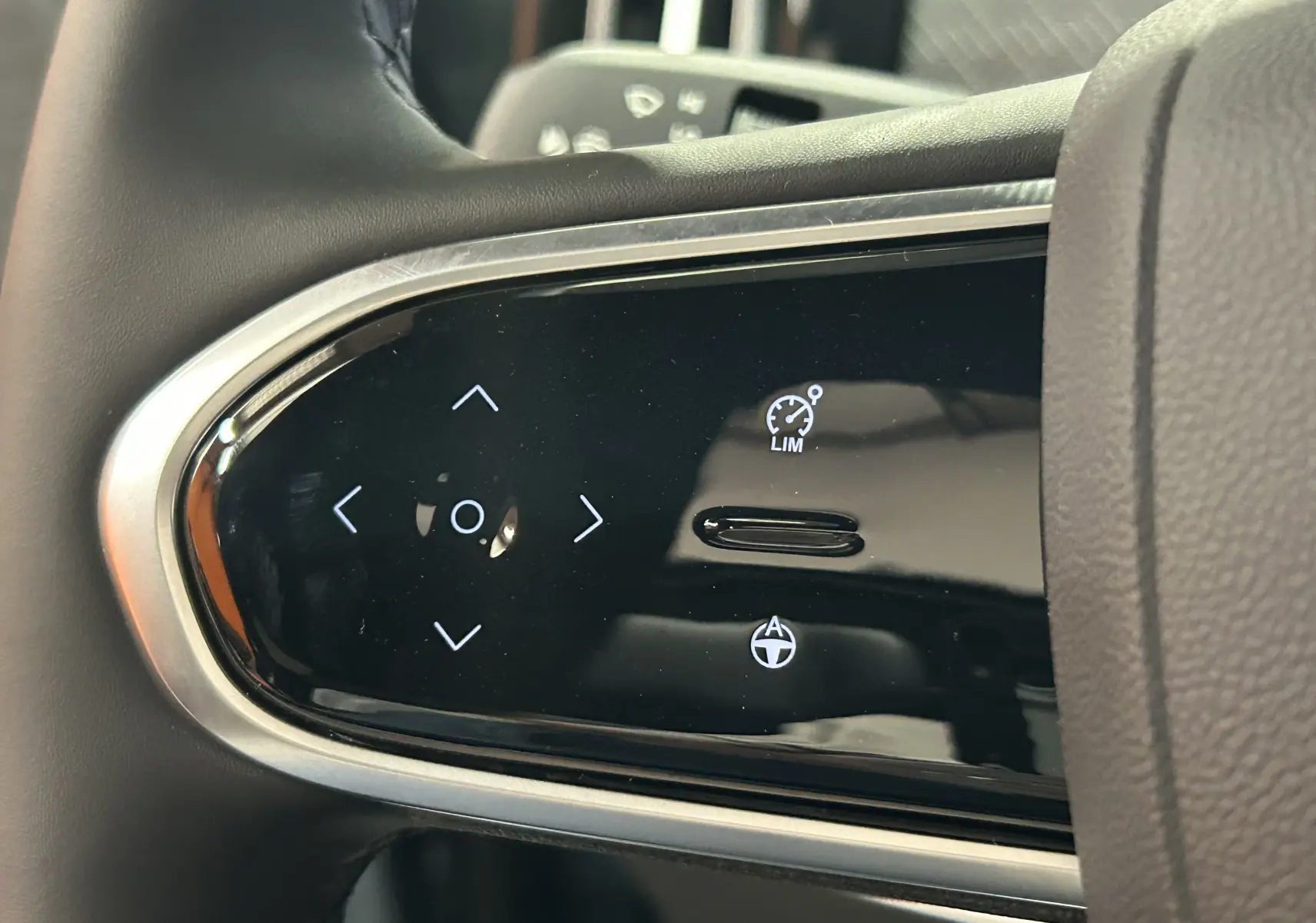 Gros plan sur les commandes tactiles noires du volant du JAECOO J7 TGDI PHEV 279CH EXCLUSIVE, finition cuir gris-noir.