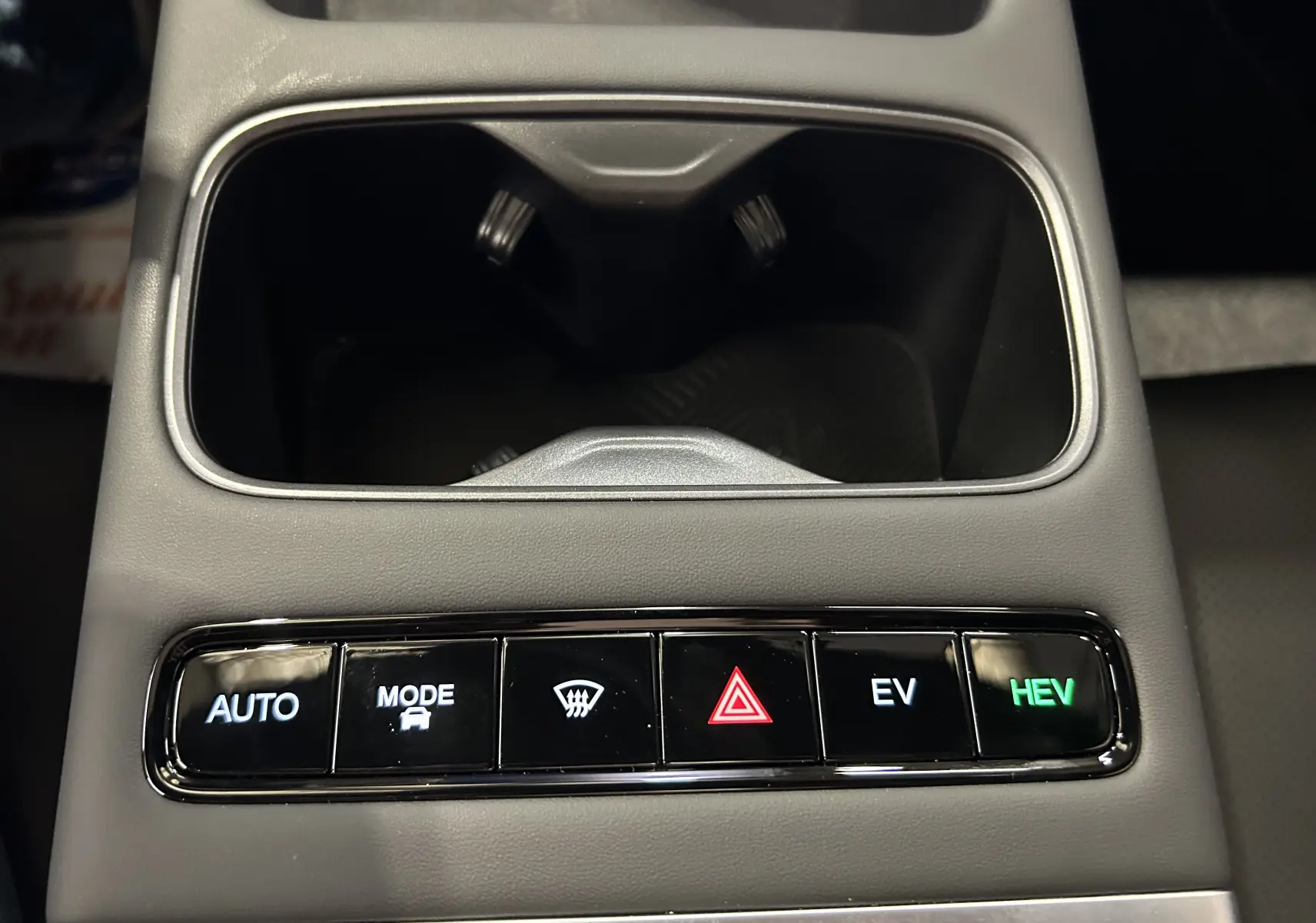 Gros plan sur la console centrale grise olive du JAECOO J7 avec boutons de mode de conduite et alertes lumineux.