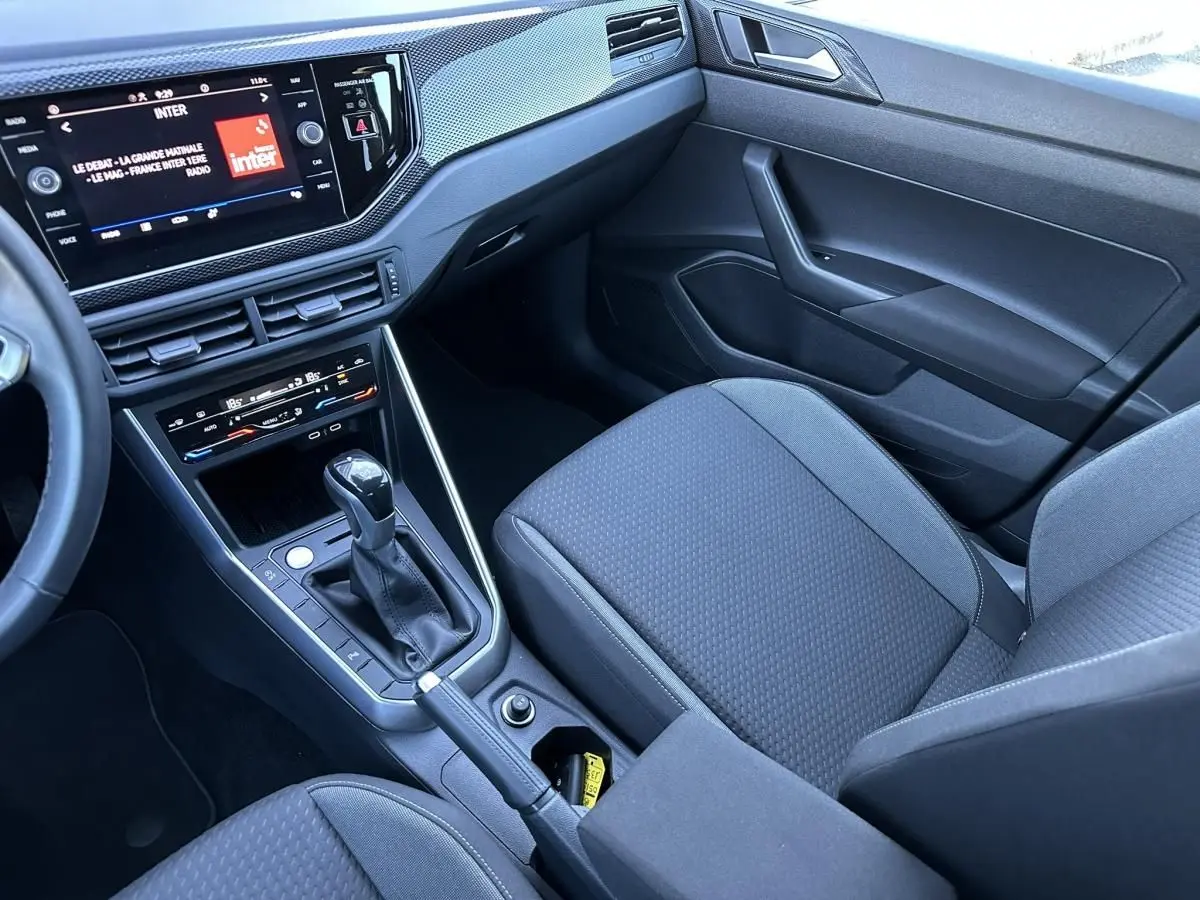 Vue intérieure côté passager du Volkswagen Taigo 1.0 TSI DSG Life Plus 2025, avec console centrale et écran tactile.