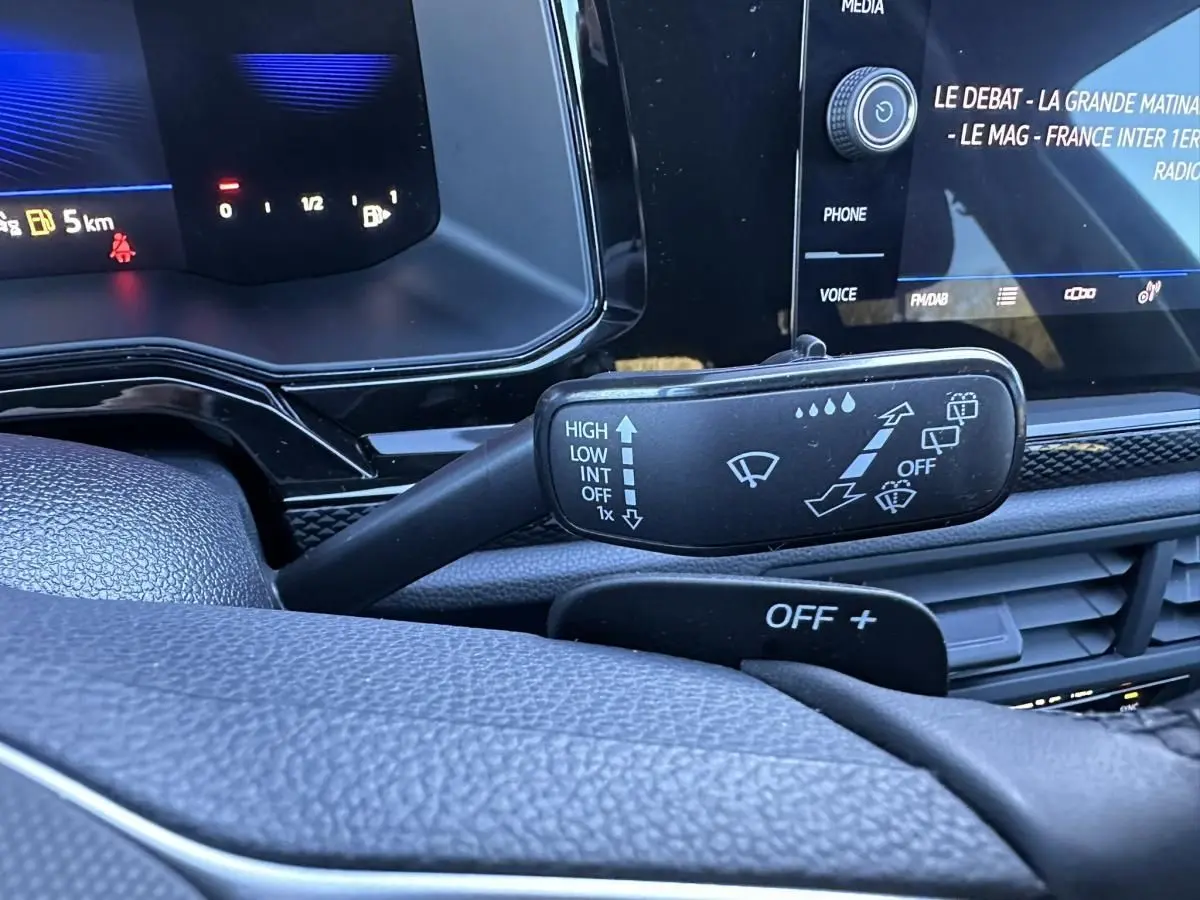 Gros plan sur la manette d’essuie-glace à gauche du volant dans l’habitacle du Volkswagen Taigo bleu Recife 2025.