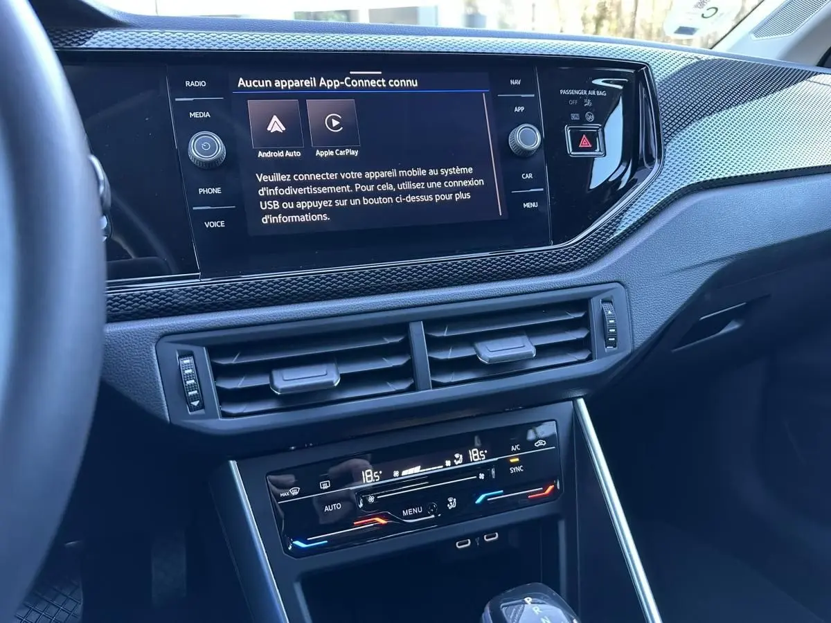Vue rapprochée de la console centrale du Volkswagen Taigo 1.0 TSI DSG Life Plus 2025, affichage tactile et commandes climatisation.