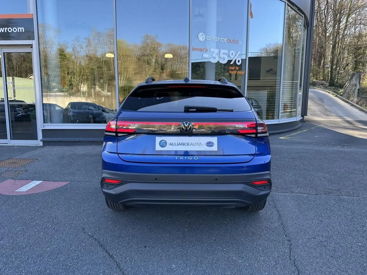 Vue arrière du Volkswagen Taigo bleu Recife 2025, avec feux LED reliés et lunette arrière teintée.