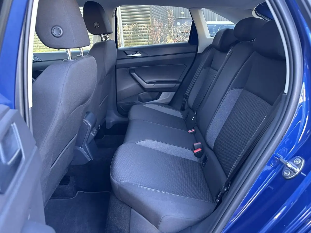 Vue intérieure côté droit des sièges arrière en tissu gris foncé du Volkswagen Taigo Bleu Recife 2025.