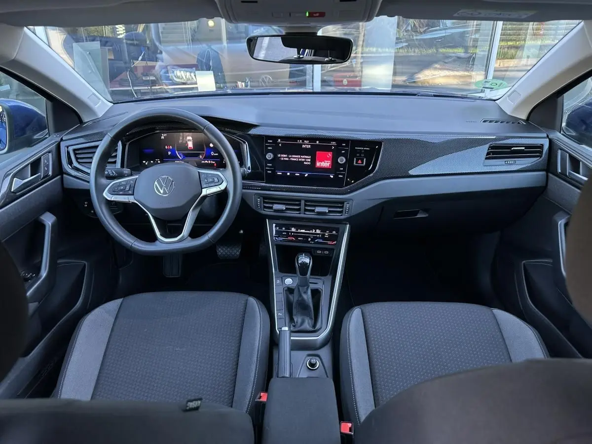 Vue intérieure frontale du tableau de bord et volant du Volkswagen Taigo 2025 avec écran tactile et console centrale noire.