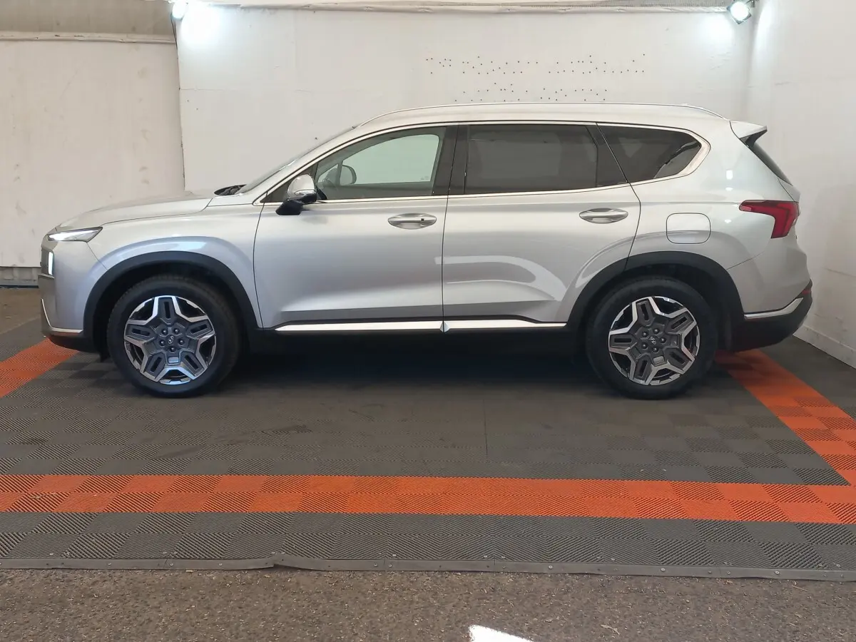 Vue latérale droite d’un Hyundai Santa Fe gris clair 2022 avec jantes alliage et lignes épurées.