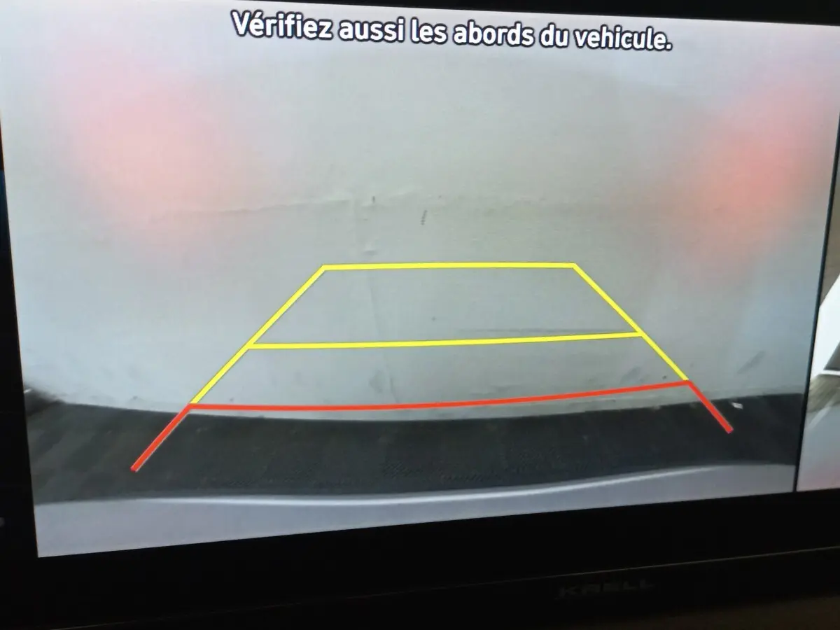 Image de la caméra de recul du Hyundai Santa Fe 2022, affichant les lignes de guidage jaunes et rouges sur fond gris.
