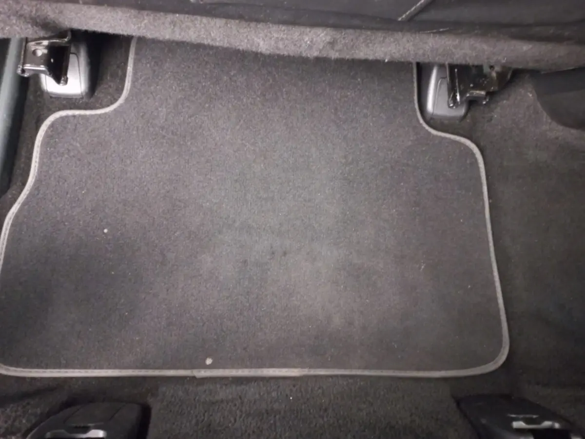 Tapis de sol noir vu de dessus dans l'habitacle arrière d'un Hyundai Santa Fe gris clair 2022 hybride rechargeable.