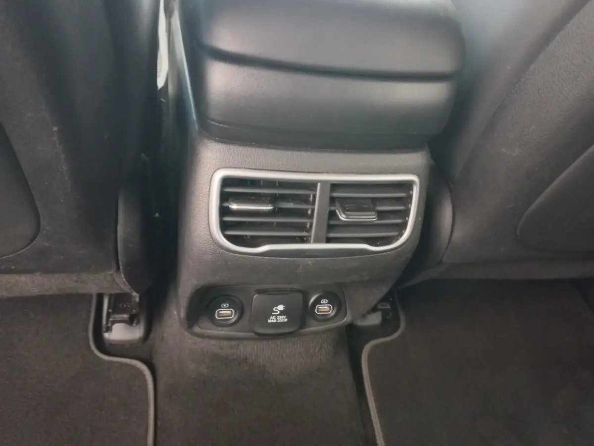 Détail de la console arrière noire avec bouches d’aération et prises USB du Hyundai Santa Fe gris clair 2022.