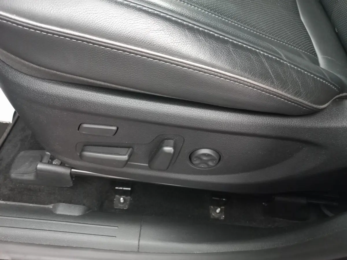 Gros plan sur les commandes de réglage électrique du siège en cuir noir côté conducteur du Hyundai Santa Fe gris clair 2022.