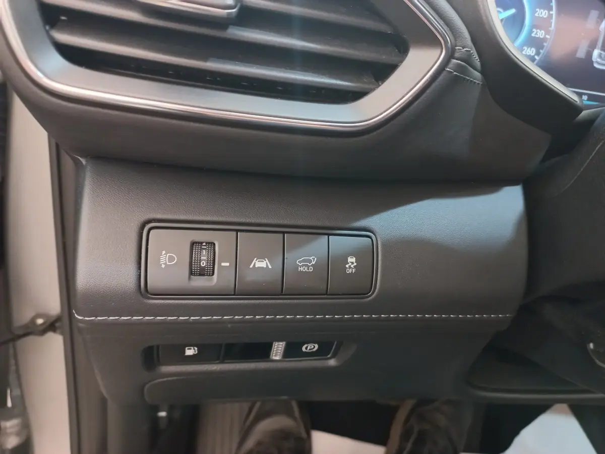 Détail du tableau de bord côté gauche du Hyundai Santa Fe gris clair, avec commandes d’éclairage et aides à la conduite.