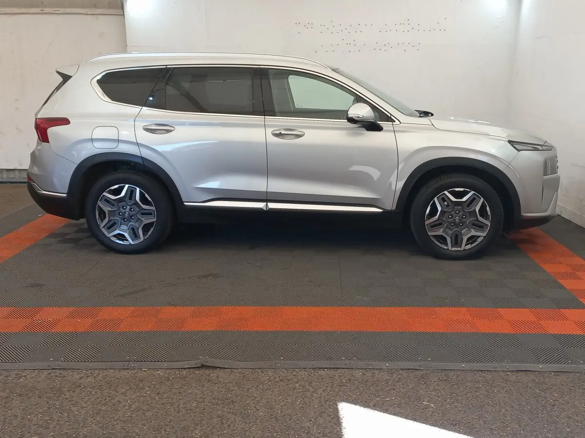 Vue de profil côté droit d'un Hyundai Santa Fe gris clair 2022 avec jantes alliage et toit ouvrant électrique.