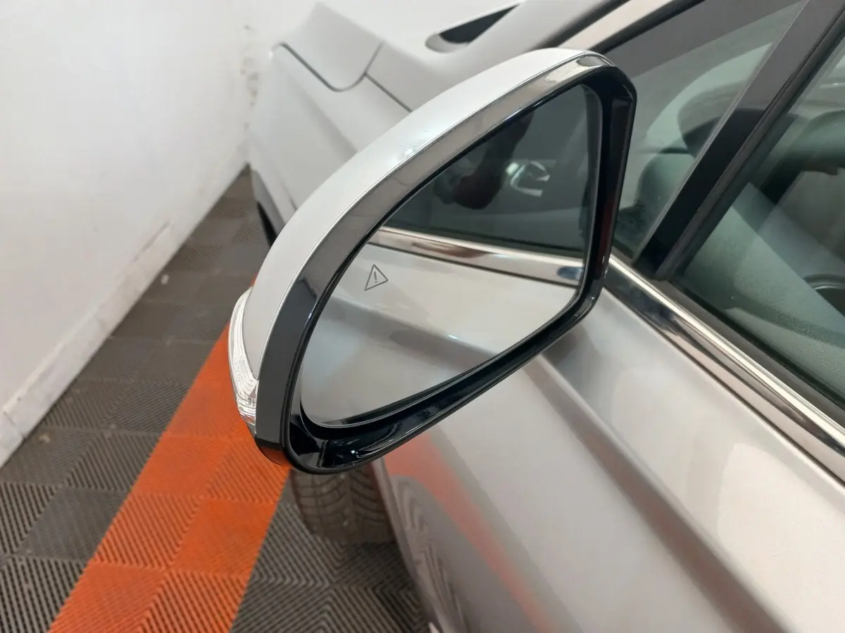 Rétroviseur côté gauche gris clair du Hyundai Santa Fe 2022 avec clignotant intégré, vue rapprochée en intérieur.