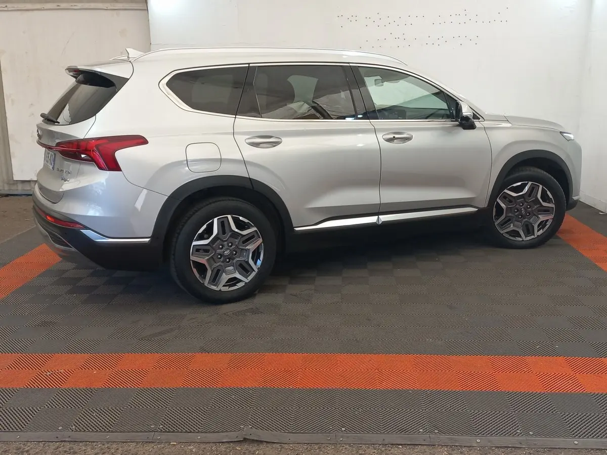 Vue latérale droite d'un Hyundai Santa Fe gris clair avec jantes alliage et toit ouvrant électrique.