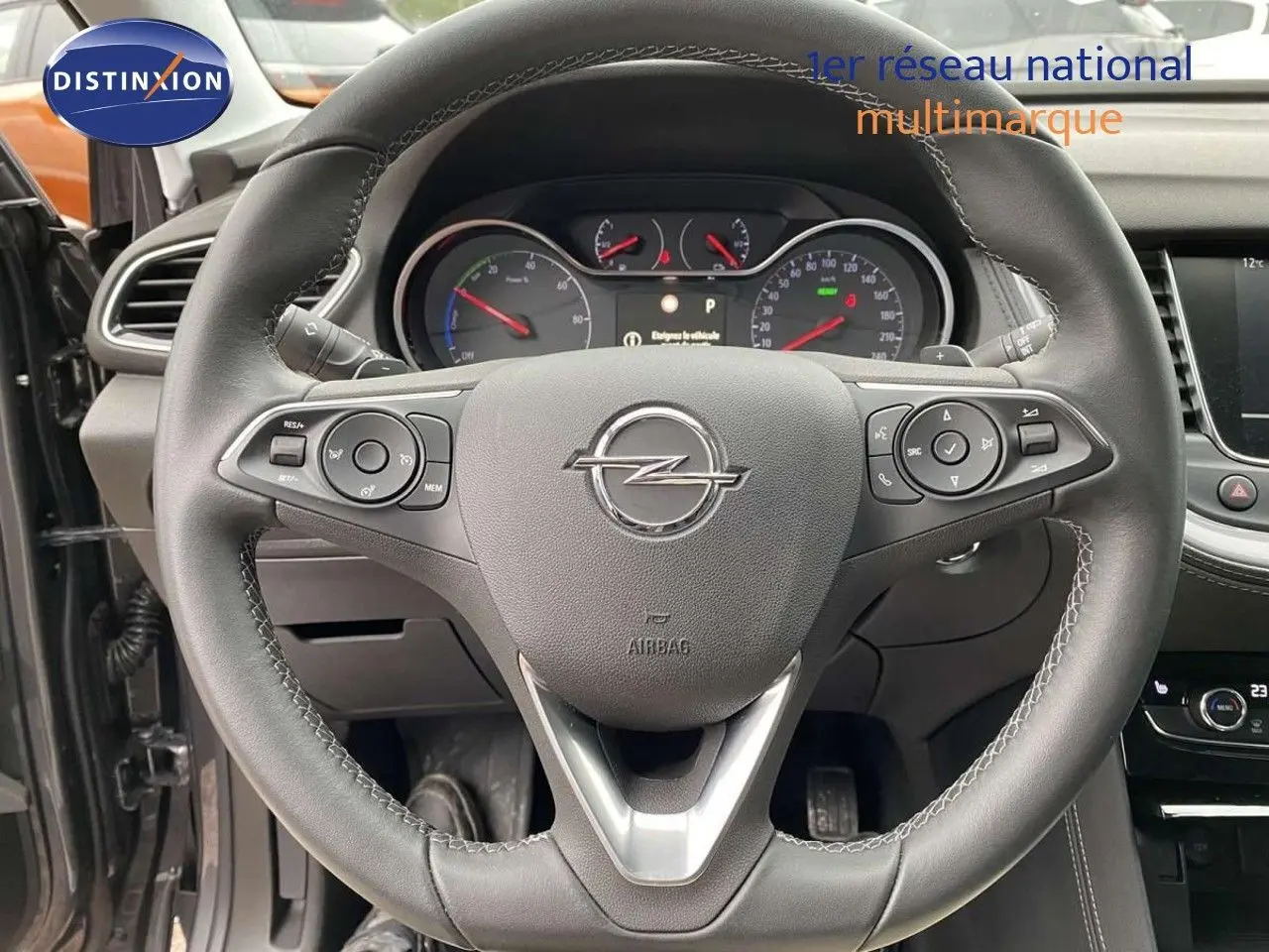 Volant en cuir noir de l'Opel Grandland X hybride 2021 avec commandes intégrées et tableau de bord visible.
