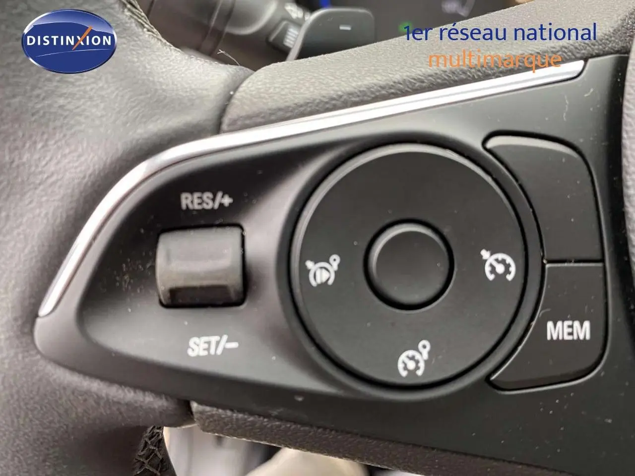 Gros plan sur les commandes de régulateur de vitesse au volant d'un Opel Grandland X gris Moai Metal 2021.