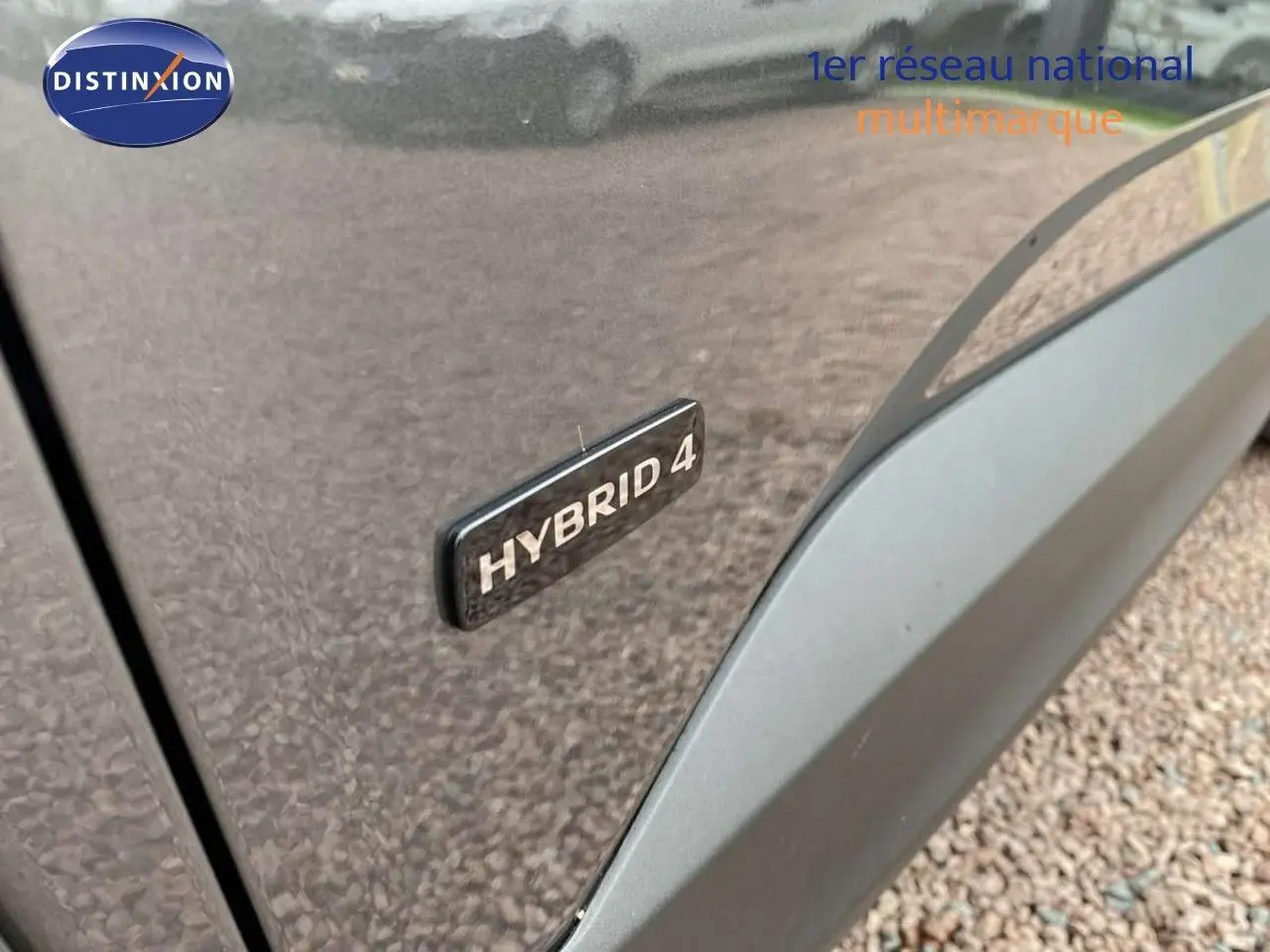 Gros plan sur l’inscription Hybrid 4 sur la porte côté gauche d’un Opel Grandland X gris Moai Metal.