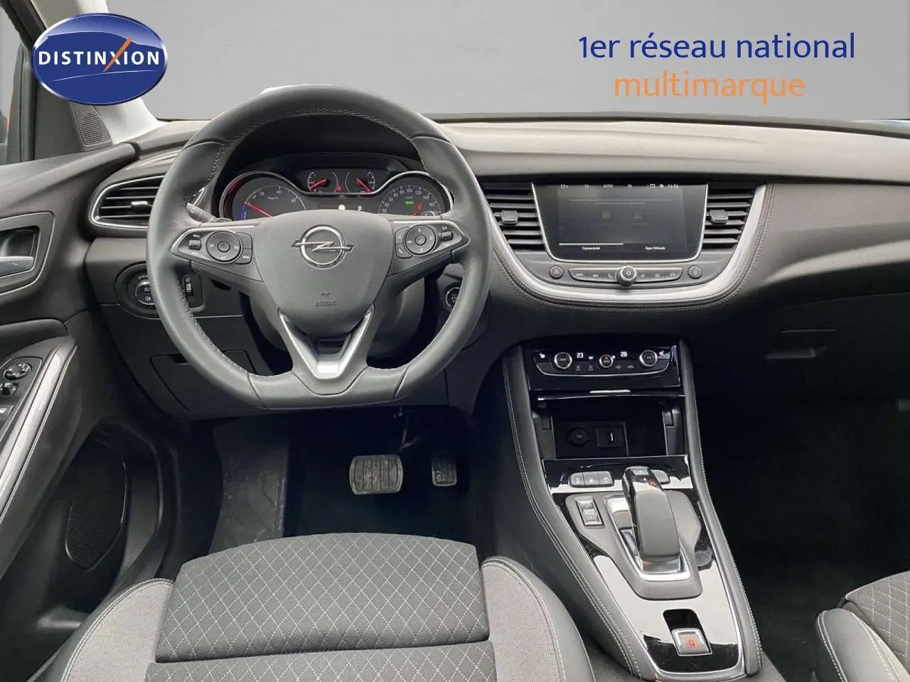 Intérieur de l’Opel Grandland X gris Moai Metal, vue centrée sur le volant et la console centrale moderne.