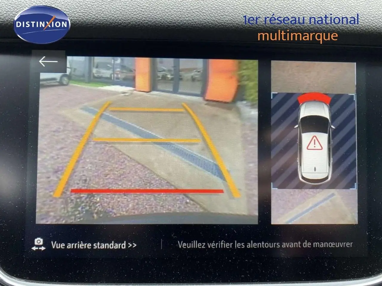 Affichage caméra de recul et vue aérienne du Grandland X gris Moai Metal en stationnement, avec repères de guidage colorés.