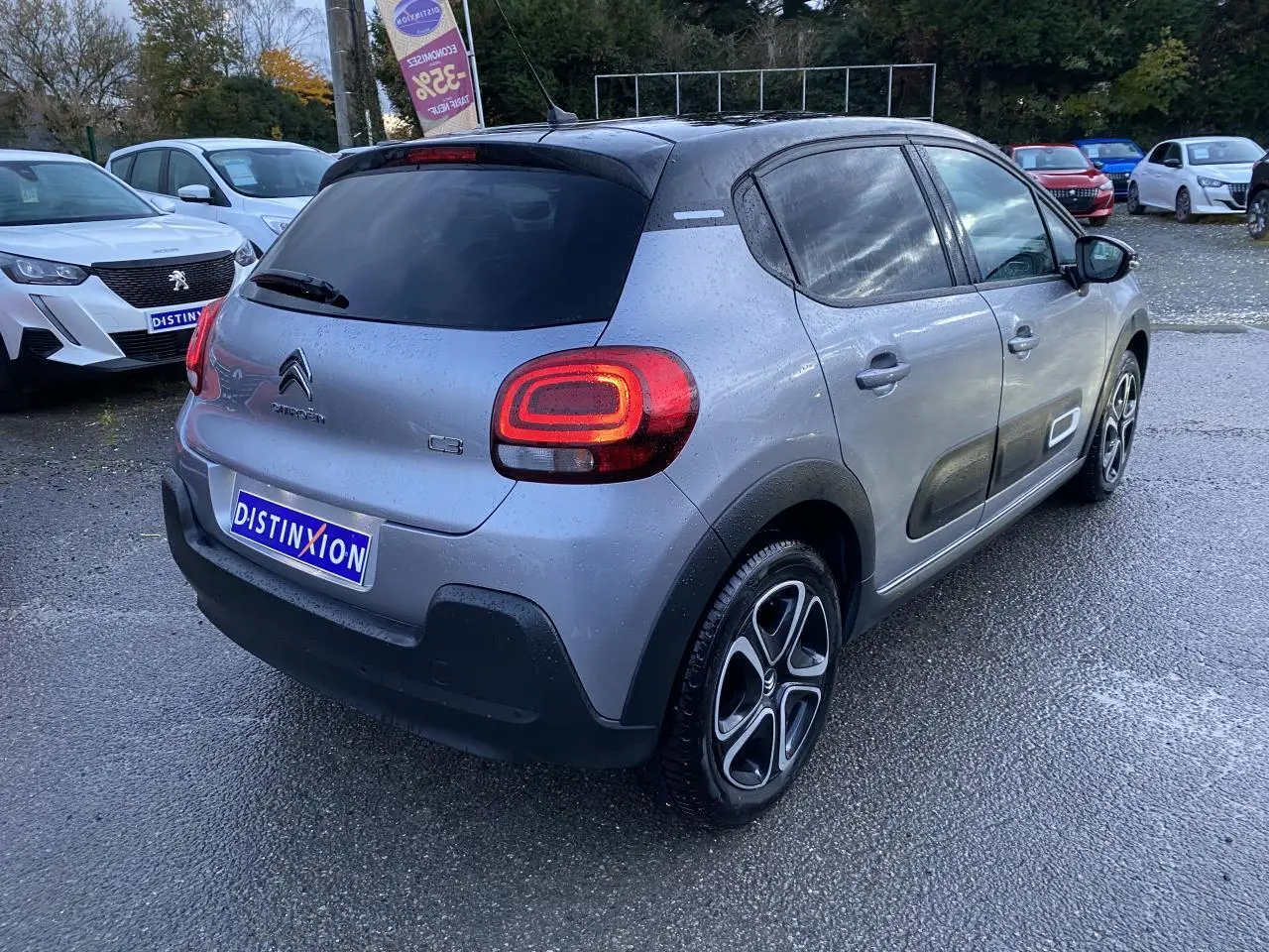 Vue 3/4 arrière droite d'une Citroën C3 gris Artense avec toit noir et jantes alliage diamantées.